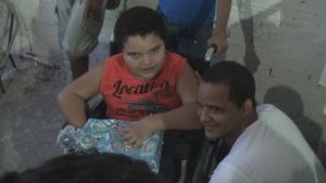 Jece Júnior entrega brinquedo ao garoto.